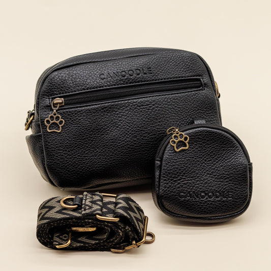 Black leather bags with paw print designs on a beige background
