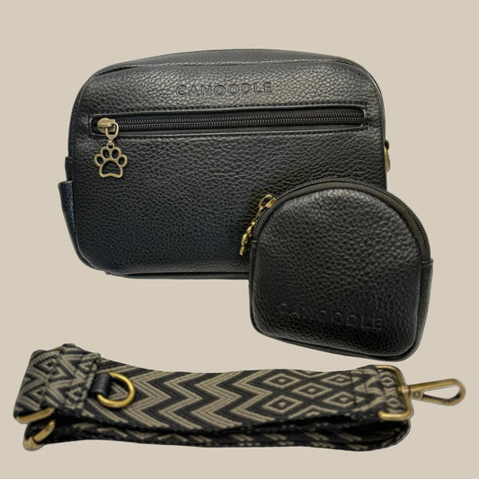 Black leather bag with a smaller round pouch and patterned strap on a white background